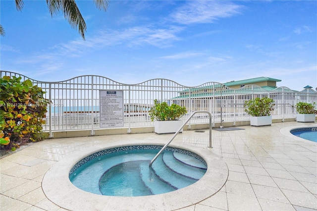 view of pool featuring a community hot tub and a water view