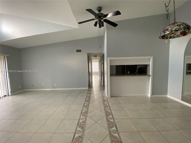 unfurnished living room with ceiling fan, light tile patterned floors, and high vaulted ceiling