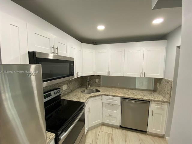 kitchen featuring sink, white cabinets, stainless steel appliances, and tasteful backsplash