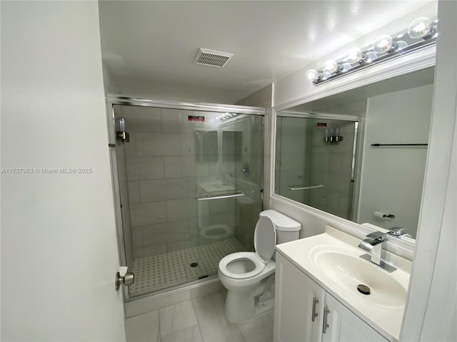 bathroom featuring tile patterned floors, toilet, vanity, and walk in shower