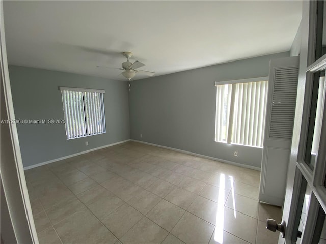 tiled empty room featuring ceiling fan and plenty of natural light