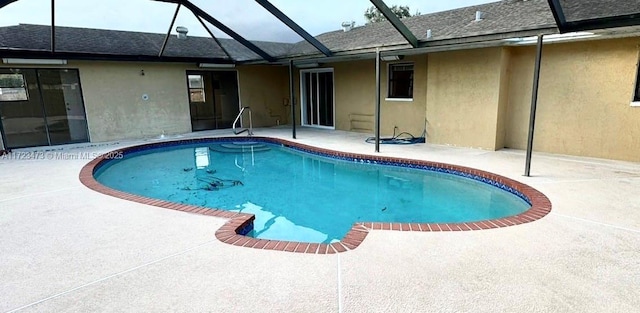 view of swimming pool featuring a lanai and a patio