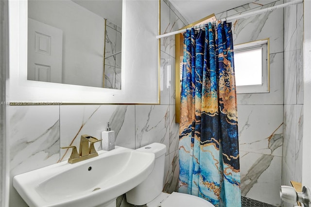 bathroom featuring toilet, a shower with shower curtain, tile walls, and sink