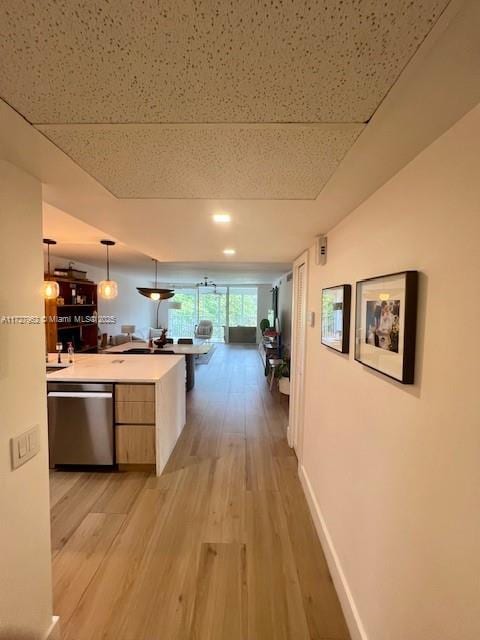 corridor with light hardwood / wood-style floors