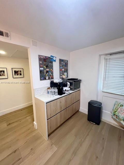 kitchen with light brown cabinetry and light hardwood / wood-style floors