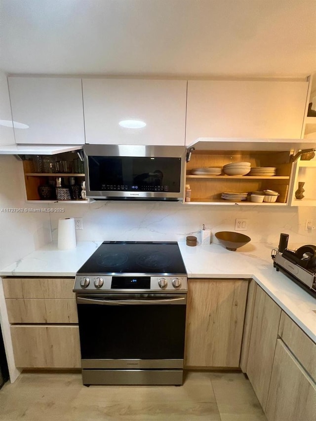 kitchen with light brown cabinetry and appliances with stainless steel finishes