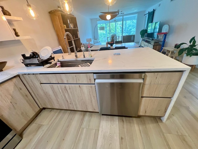 kitchen with light brown cabinets, stainless steel dishwasher, pendant lighting, sink, and light wood-type flooring