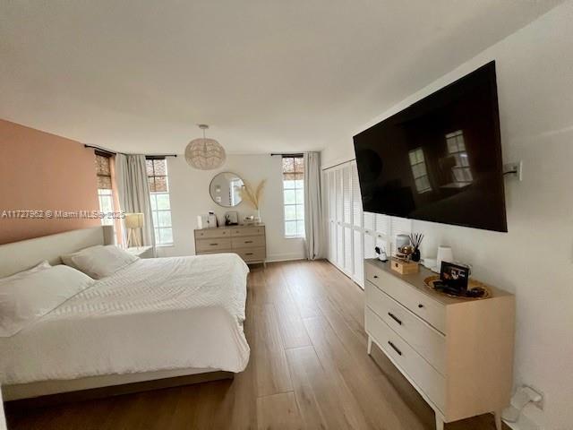 bedroom featuring multiple windows and light hardwood / wood-style flooring