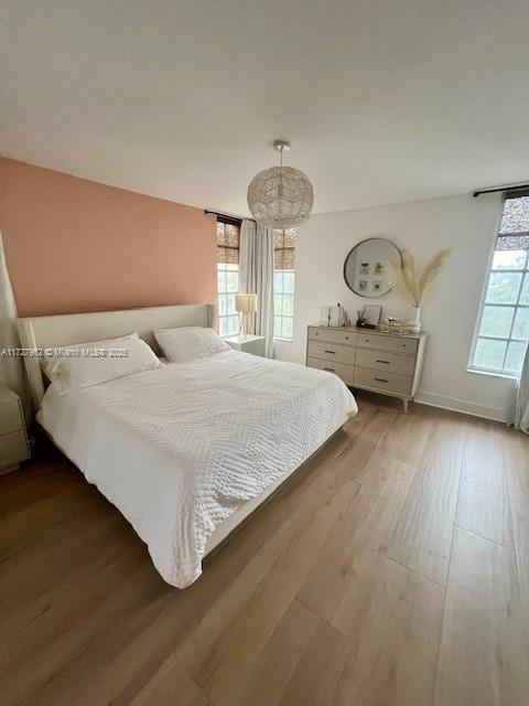 bedroom featuring hardwood / wood-style floors and multiple windows