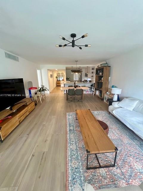 living room featuring hardwood / wood-style flooring and a chandelier