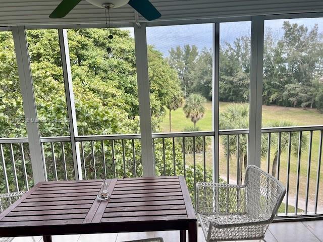 unfurnished sunroom featuring a healthy amount of sunlight and ceiling fan