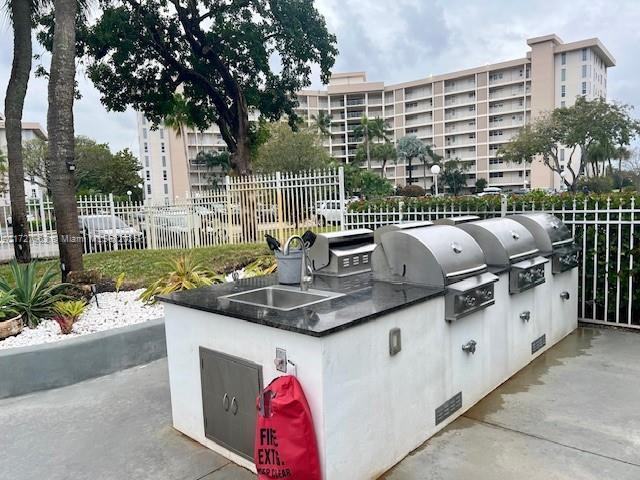 view of patio with sink, an outdoor kitchen, and grilling area