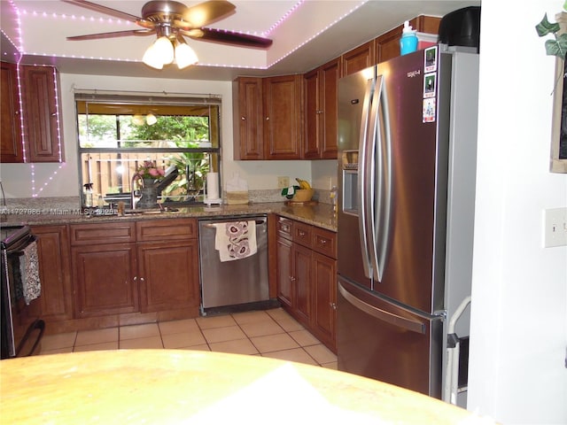 kitchen featuring ceiling fan, sink, stainless steel appliances, light tile patterned floors, and light stone counters