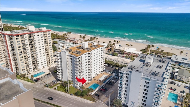 drone / aerial view featuring a water view and a view of the beach