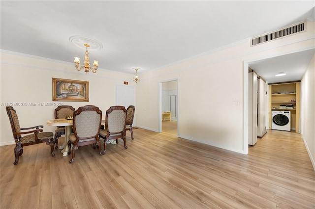 dining area with washer / clothes dryer, ornamental molding, a chandelier, and light hardwood / wood-style flooring