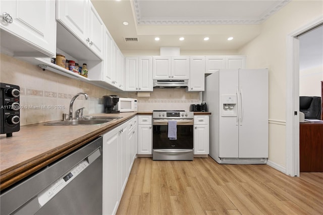 kitchen featuring sink, crown molding, appliances with stainless steel finishes, white cabinetry, and tasteful backsplash