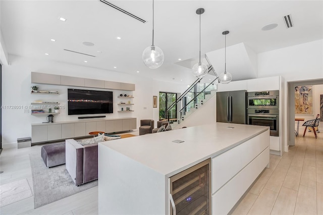 kitchen featuring white cabinetry, appliances with stainless steel finishes, pendant lighting, and wine cooler