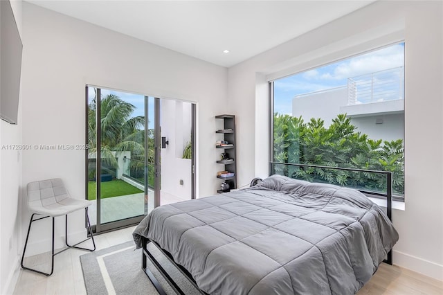 bedroom with access to outside and light hardwood / wood-style floors