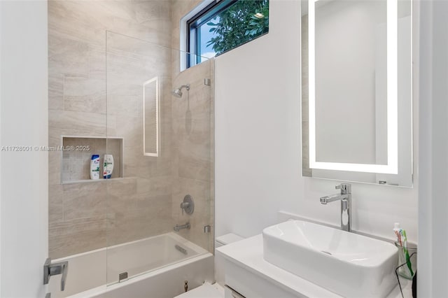 full bathroom featuring tiled shower / bath combo, vanity, and toilet