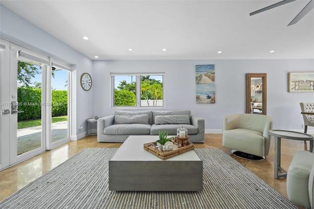 living room featuring ceiling fan and a wealth of natural light