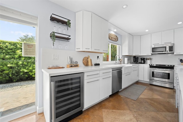 kitchen featuring stainless steel appliances, wine cooler, and white cabinetry