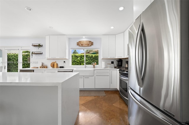 kitchen featuring a wealth of natural light, stainless steel appliances, white cabinets, and sink