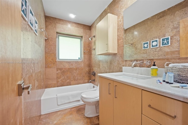 full bathroom with tile walls, toilet, vanity, and shower / washtub combination