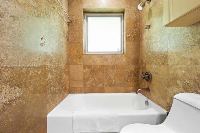 bathroom featuring toilet and tiled shower / bath combo