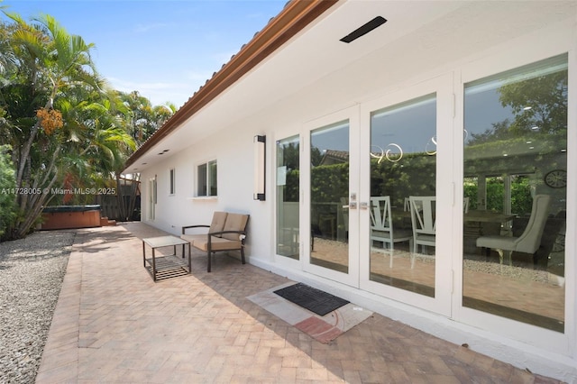 view of patio / terrace featuring a hot tub and french doors