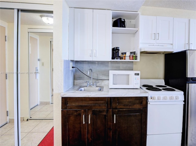 kitchen featuring white appliances, white cabinets, sink, light tile patterned floors, and dark brown cabinets