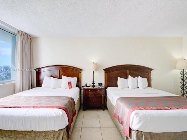 bedroom with a textured ceiling and light tile patterned floors