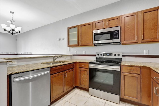 kitchen featuring light tile patterned floors, stainless steel appliances, a notable chandelier, pendant lighting, and sink