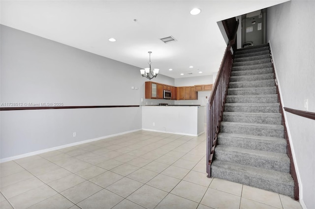 stairs with a notable chandelier and tile patterned flooring