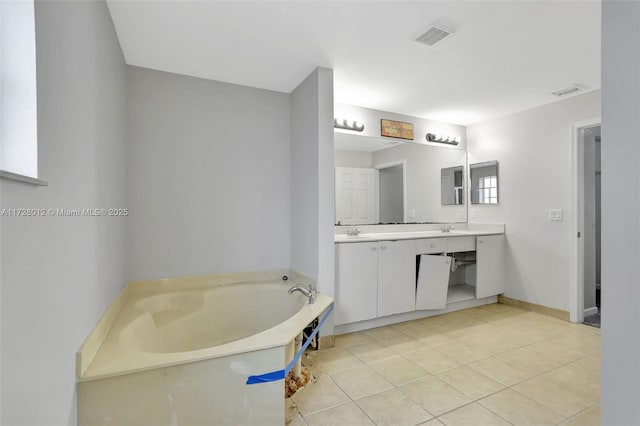 bathroom with tile patterned flooring, vanity, and a tub