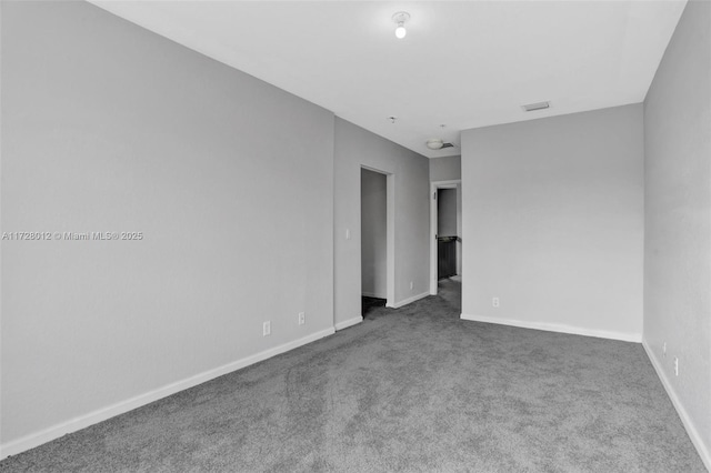 spare room featuring dark colored carpet