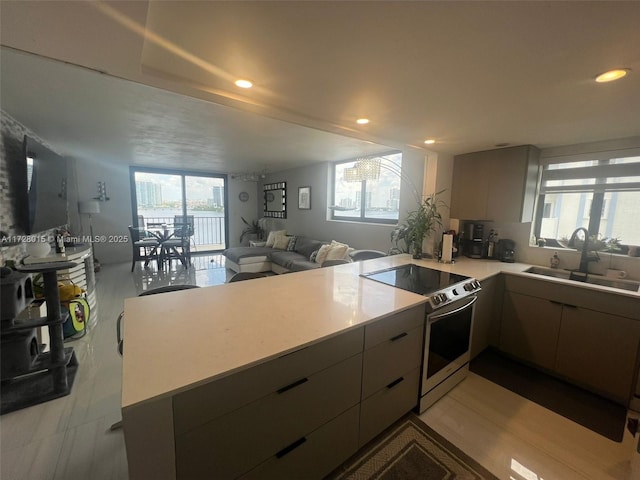 kitchen with sink, kitchen peninsula, and stainless steel range with electric cooktop