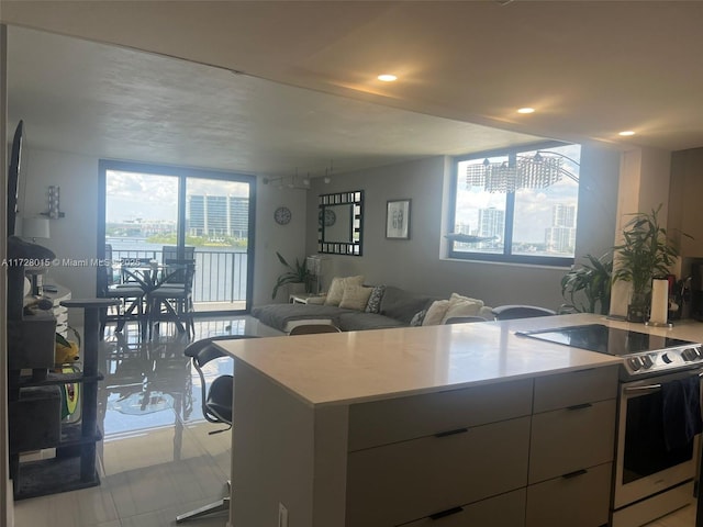 kitchen featuring electric stove, light tile patterned flooring, and a kitchen island