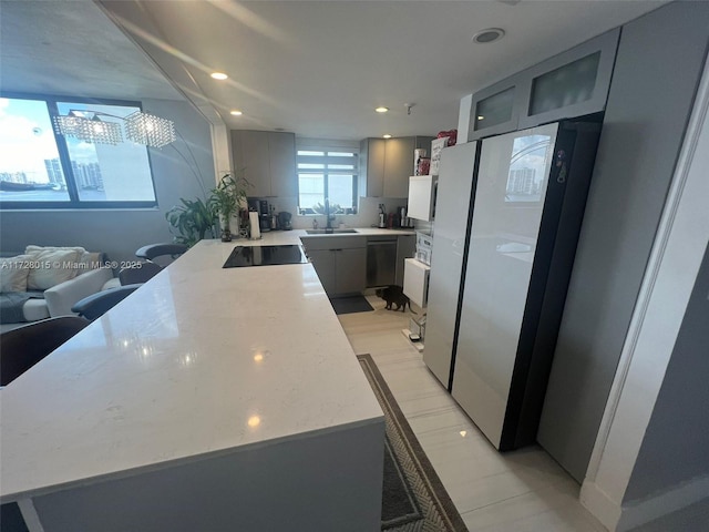 kitchen with light stone counters, sink, gray cabinetry, and black appliances