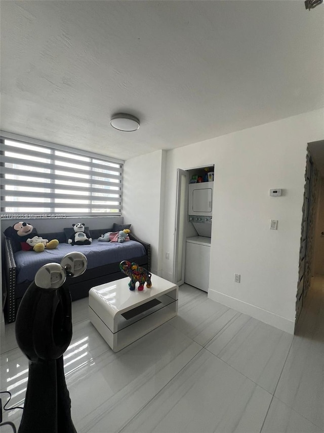 living room featuring light tile patterned floors and stacked washer and clothes dryer