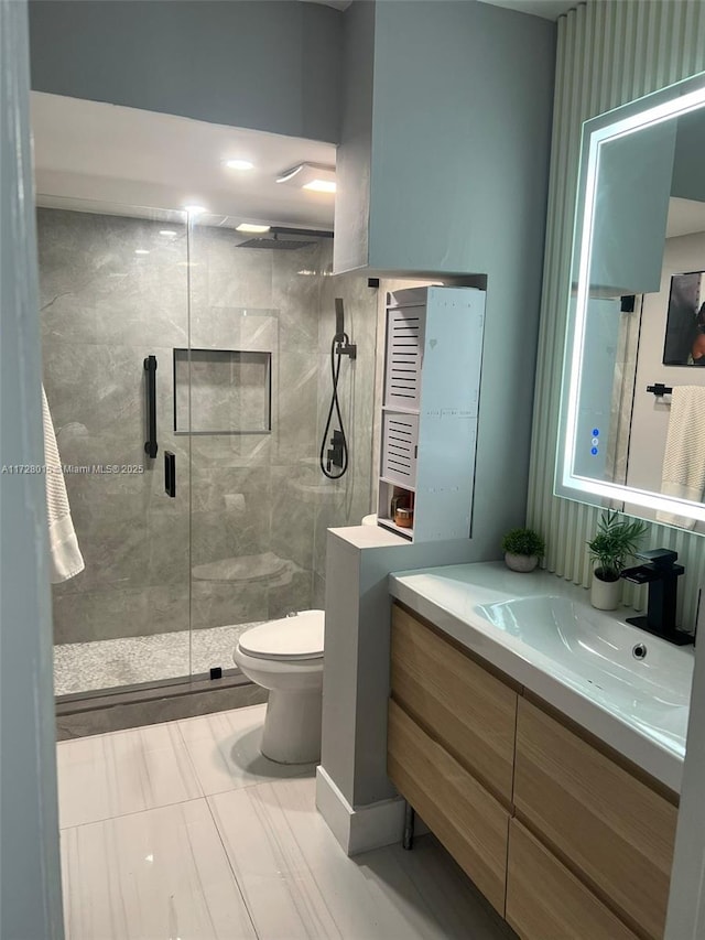 bathroom with walk in shower, vanity, tile patterned flooring, and toilet