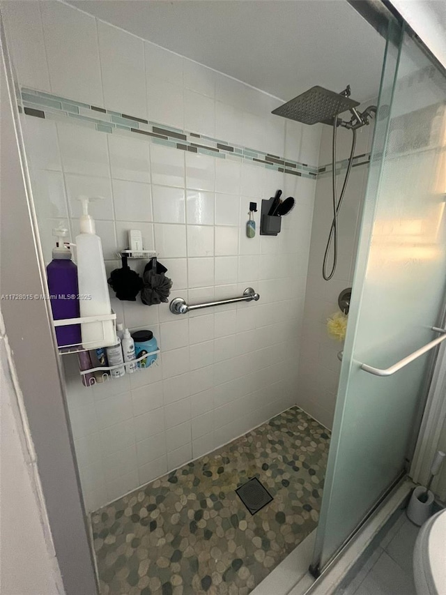 bathroom featuring tile walls, toilet, walk in shower, and tile patterned flooring