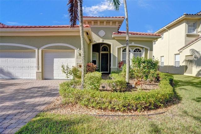 mediterranean / spanish home featuring a front lawn and a garage