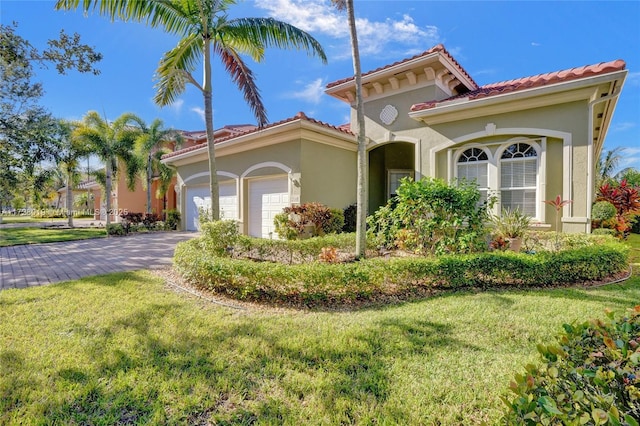 mediterranean / spanish house with a garage and a front lawn