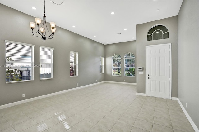 tiled foyer featuring a notable chandelier and a high ceiling