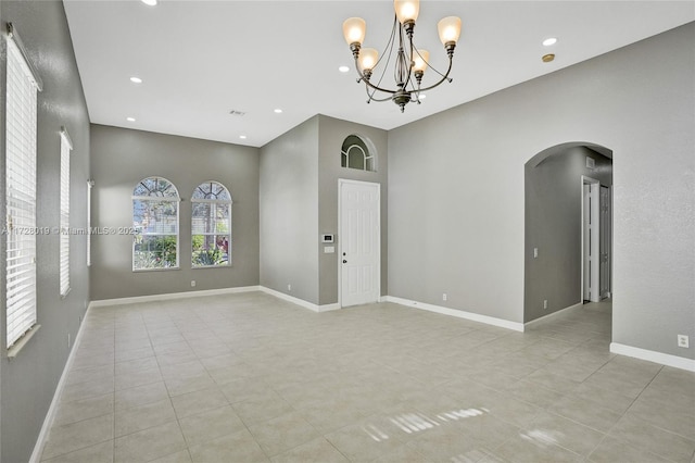 unfurnished room featuring light tile patterned floors and a chandelier