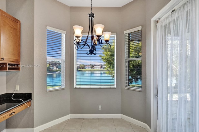 unfurnished dining area featuring light tile patterned floors and a chandelier