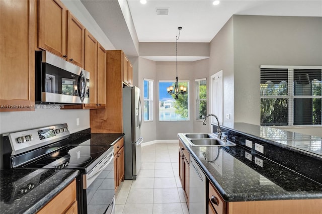 kitchen featuring decorative light fixtures, a notable chandelier, dark stone countertops, sink, and appliances with stainless steel finishes