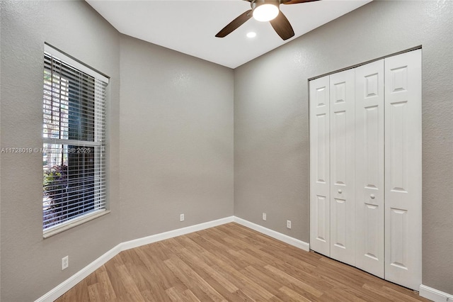 unfurnished bedroom featuring ceiling fan, light wood-type flooring, and a closet