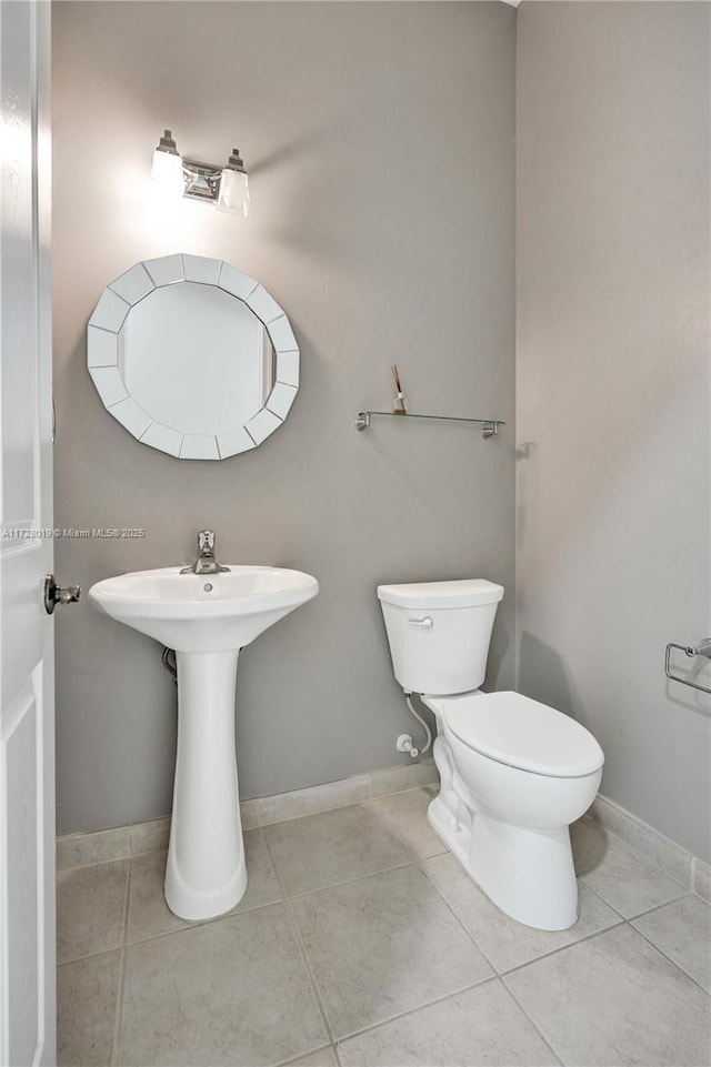 bathroom with toilet and tile patterned flooring