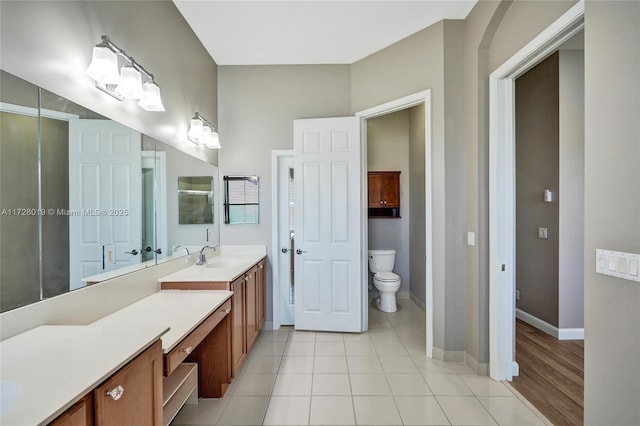 bathroom with toilet, tile patterned floors, and vanity